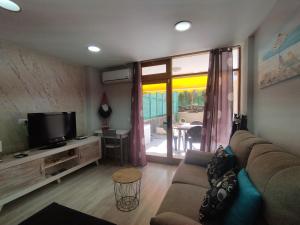 a living room with a couch and a flat screen tv at Arenas 50, 100 mt d playa ingles in Playa del Ingles
