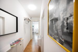 un pasillo con paredes blancas y una foto en la pared en Appartamento Tanja Trieste, en Trieste