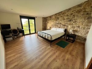 Un dormitorio con una cama y una pared de piedra. en Casa Alvite, en Cayón (Caión) 30 fotos más