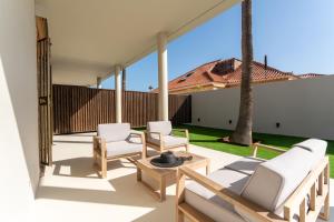 patio con tavolo e sedie bianche di Vivelorural Villa Oscar 2, Maspalomas a San Bartolomé