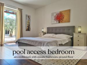 a bedroom with a bed and a large window at Spacious villa with pool, indoor jacuzzi and sauna near Poreč in Višnjan