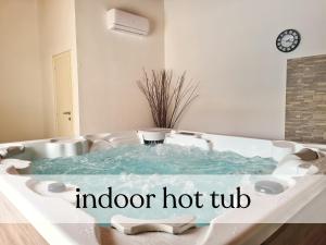a hot tub in a bathroom with a signidding at Spacious villa with pool, indoor jacuzzi and sauna near Poreč in Višnjan