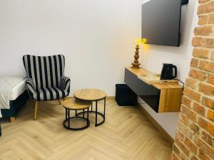 a living room with a chair and a table at Hotel & Restauracja Kormoran in Orzysz +16 photos