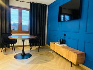 a dining room with a table and a blue wall at Hotel & Restauracja Kormoran in Orzysz