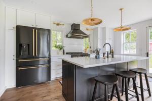 a kitchen with a stainless steel refrigerator and bar stools at Willard House in Bayfield