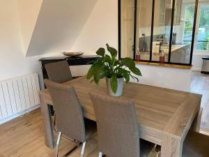 a dining room table and chairs with a potted plant at Little Paradise - Comfort and Quiet Getaway by the Eure in Montreuil +17 photos