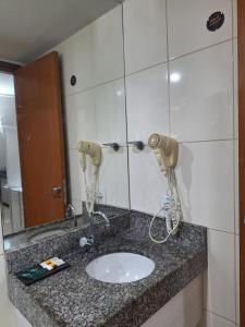 eine Badezimmerablage mit Waschbecken und Spiegel in der Unterkunft Apartamento BLUE in João Pessoa