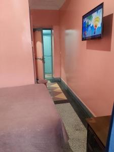 - une chambre avec un lit et une télévision murale dans l'établissement Hôtel Volubilis, à Casablanca