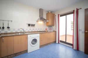 eine Küche mit einer Waschmaschine und einem Waschbecken in der Unterkunft Apartamento ateneo in Sanlúcar de Barrameda
