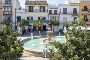 Eine Frau, die vor einem Brunnen sitzt. in der Unterkunft Apartamento ateneo in Sanlúcar de Barrameda