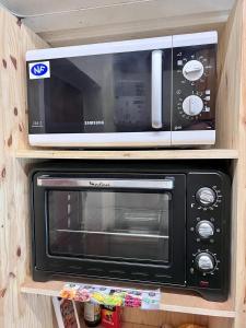 un horno microondas en la parte superior de un estante en Appartement cosy à Bagnères-de-Bigorre, 34 m² avec balcon, en La Mongie