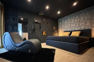 una camera con una sedia blu e un letto di Love Room & Spa, L'Atelier des Sens a Mons-en-Pévèle
