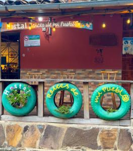 three green inflatable plants sitting on a fence in front of a building at Hostal Raíces de mi Pueblo in Suchitoto