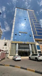 Al Hindāwīyahにあるفندق المجد Hotelの高層ビルの前に停車した車2台 +6枚の写真