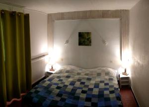 ein Schlafzimmer mit einem karierten Bett und zwei Lampen in der Unterkunft Le Pourquoi Pas in Saint-Lary-Soulan + 17 Fotos