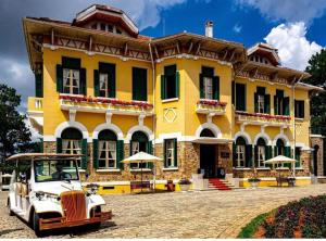 an old car parked in front of a yellow building at LILLY Hotel in Da Lat