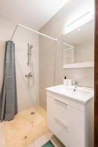 a white bathroom with a sink and a shower at City Hideaway Suite - TGV Station & Beach Walk in Tangier +14 photos