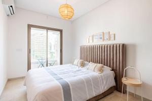 a white bedroom with a large bed and a window at City Hideaway Suite - TGV Station & Beach Walk in Tangier