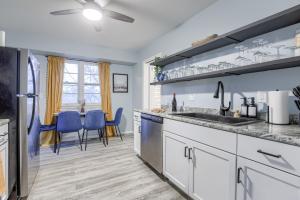 a kitchen with white cabinets and blue chairs at Central 4BD Home - Spacious Backyard & Fun Games in Omaha