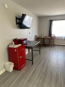 a room with a table and a tv on the wall at Motel Tipton in Tipton