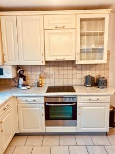 a kitchen with white cabinets and a stove top oven at Family Apartments Eichel in Rust