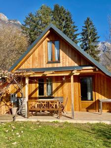 a wooden cabin with a picnic table in front of it at Sweet Bee Cottage in Bovec