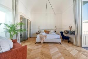 een slaapkamer met een bed, een stoel en een bank bij THE PLACE Ortigia in Siracusa +30 foto's