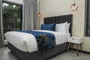 a bedroom with a large bed with a blue blanket at Residence at Montego in Sandton