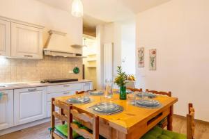 a kitchen with a wooden table and a dining room at Garden Apartment in Marina di Carrara