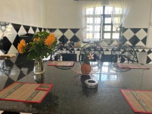 a dining room with a table with flowers and chairs at Skipper Dan Bungalow in La Gaulette