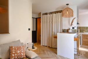a living room with a couch and a kitchen at Une perle au bord de l'eau in La Ciotat +16 photos