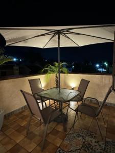 a patio with a table and chairs and an umbrella at Suite Boutique #5 Antigua Guatemala in San Pedro Las Huertas +22 photos