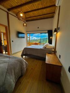 a bedroom with two beds and a large window at Cabana Mendoza - Busch Camping in Rancho Queimado