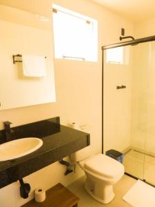 a bathroom with a toilet and a sink and a shower at Cabana Mendoza - Busch Camping in Rancho Queimado +23 photos