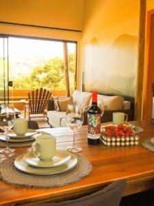 a table with two glasses and a bottle of wine at Cabana Mendoza - Busch Camping in Rancho Queimado