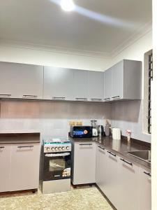 een keuken met witte kasten en een fornuis bij Luxury 1bedroom apartment in Accra +1 foto