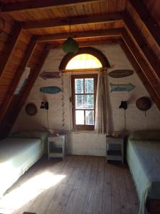 Zimmer im Dachgeschoss mit 2 Betten und einem Fenster in der Unterkunft Casa Alpina Acantilados in Mar del Plata