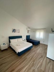 a bedroom with a large bed and a blue couch at Villetta Alcantara Apartment in Calatabiano