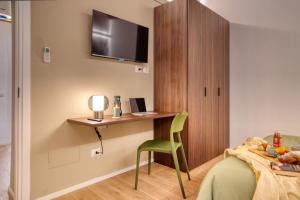 1 dormitorio con escritorio y 1 cama con silla verde en Near the Duomo, Mini Suite Navigli, en Milán