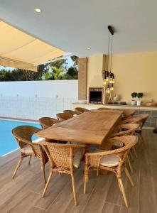 a dining room with a wooden table and chairs at Vivenda em Vilamoura Marina Ténis Academy in Vilamoura