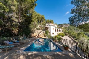 a swimming pool in front of a house at Es Carritx in Deia