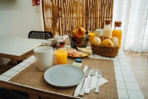 einen Frühstückstisch mit Speisen und Orangensaft in der Unterkunft Estação do Parque in Santa Maria da Feira