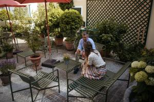 Un uomo e una donna seduti su delle sedie in giardino di Hotel Goldener Ochs a Bad Ischl