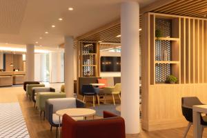 ディーゲムにあるHoliday Inn Express Brussels - Airport by IHGのテーブルと椅子が備わる待合室