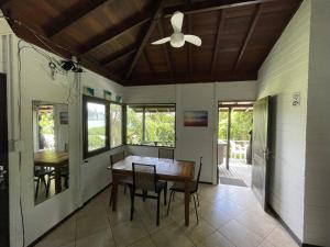 een eetkamer met een plafondventilator en een tafel bij Barra Beach Club CASAS in Florianópolis