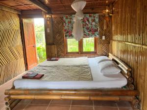 a bed in a wooden room with a window at PuBin Spice Hills in Hòa Bình