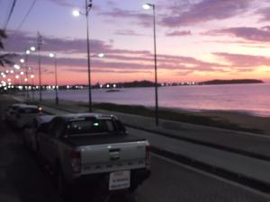 a truck parked on a road next to the ocean at Pousada Casa dos Sonhos in Rio das Ostras