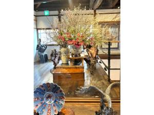 a display of vases and flowers on a table at Shiseki Ryokan Kagetsu Taishoukan - Vacation STAY 48528v in Takeo