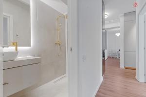 a white bathroom with a sink and a mirror at The Light Home in Bucharest +22 photos