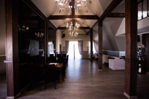 a dining room with tables and chairs and a chandelier at Royal Wood Hotel in Rokytne